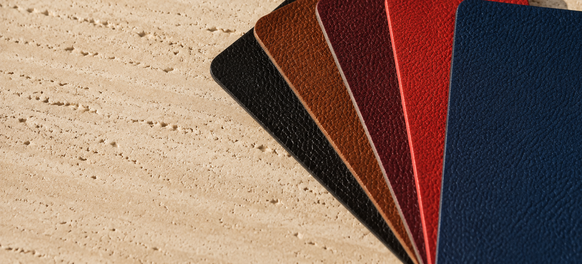 Pebbled leather swatches in five colours on travertine